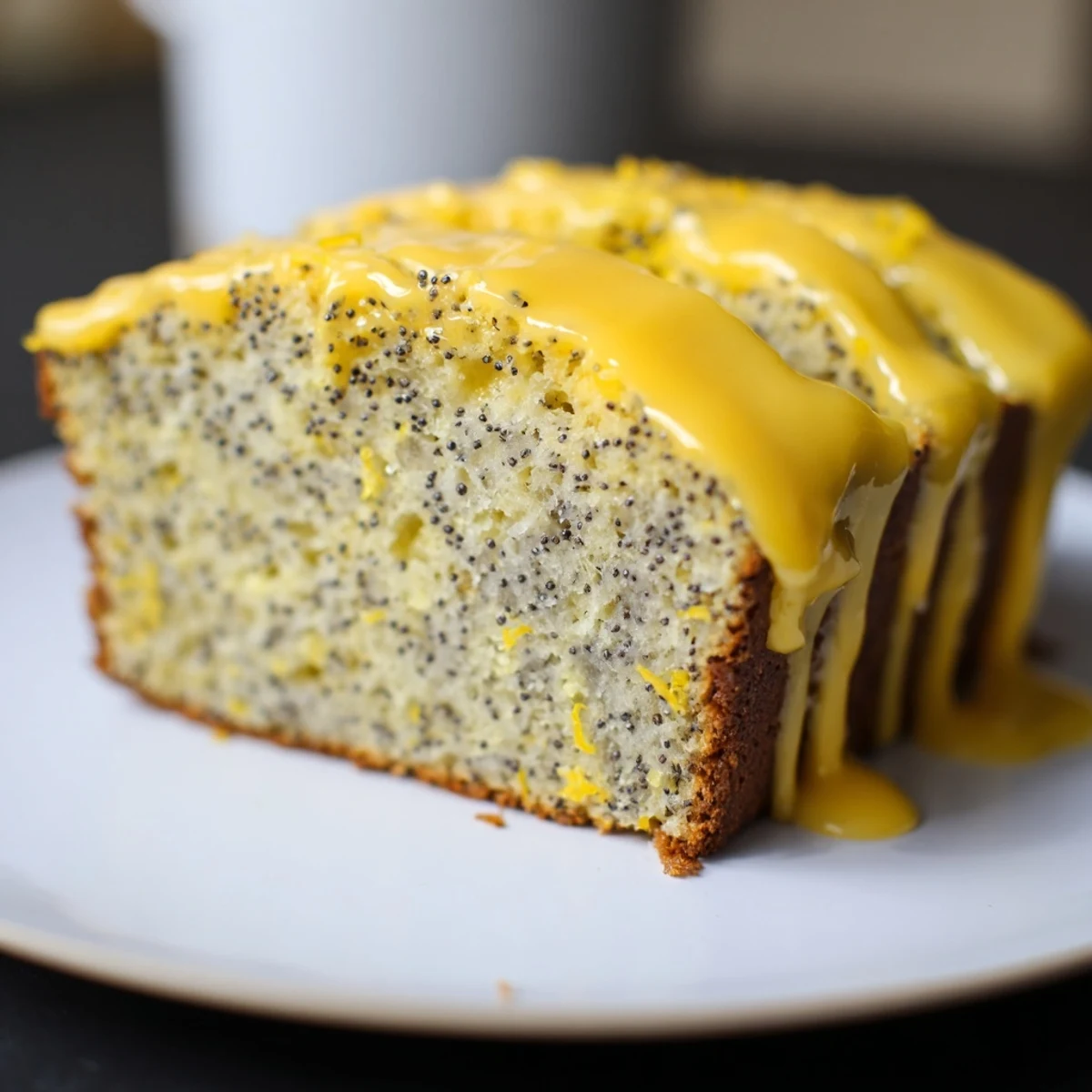This sweet Glazed Lemon Poppy Seed Cake shows a close-up of the drizzled lemon icing.