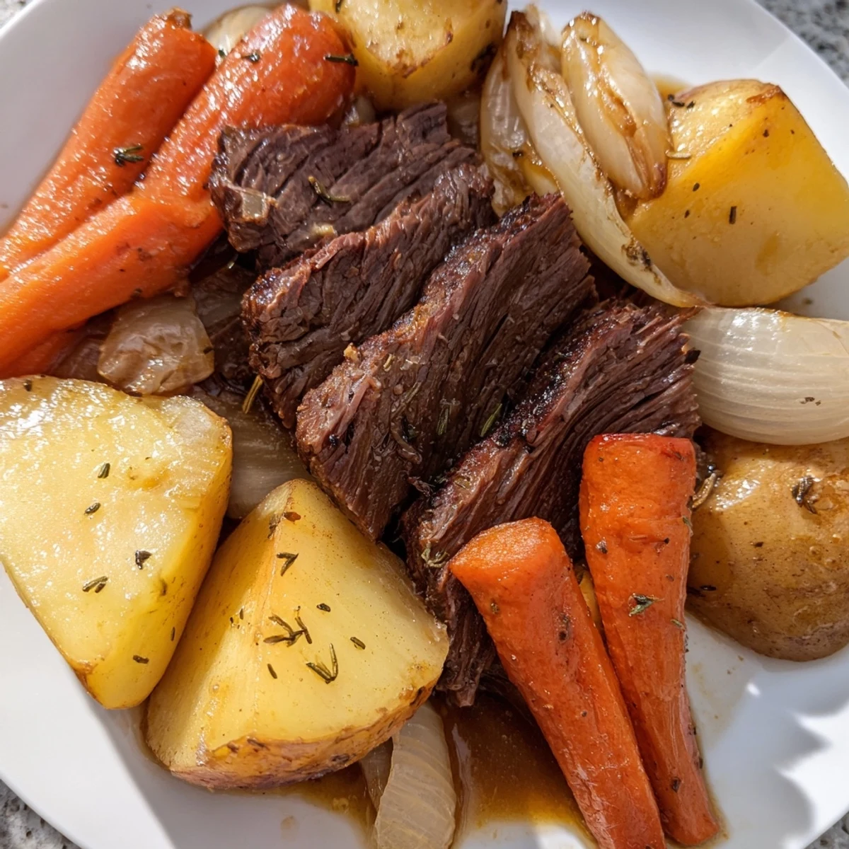 Fork-tender slices of Everyday Family Favorite Pot Roast served with carrots, potatoes, and savory juices.
