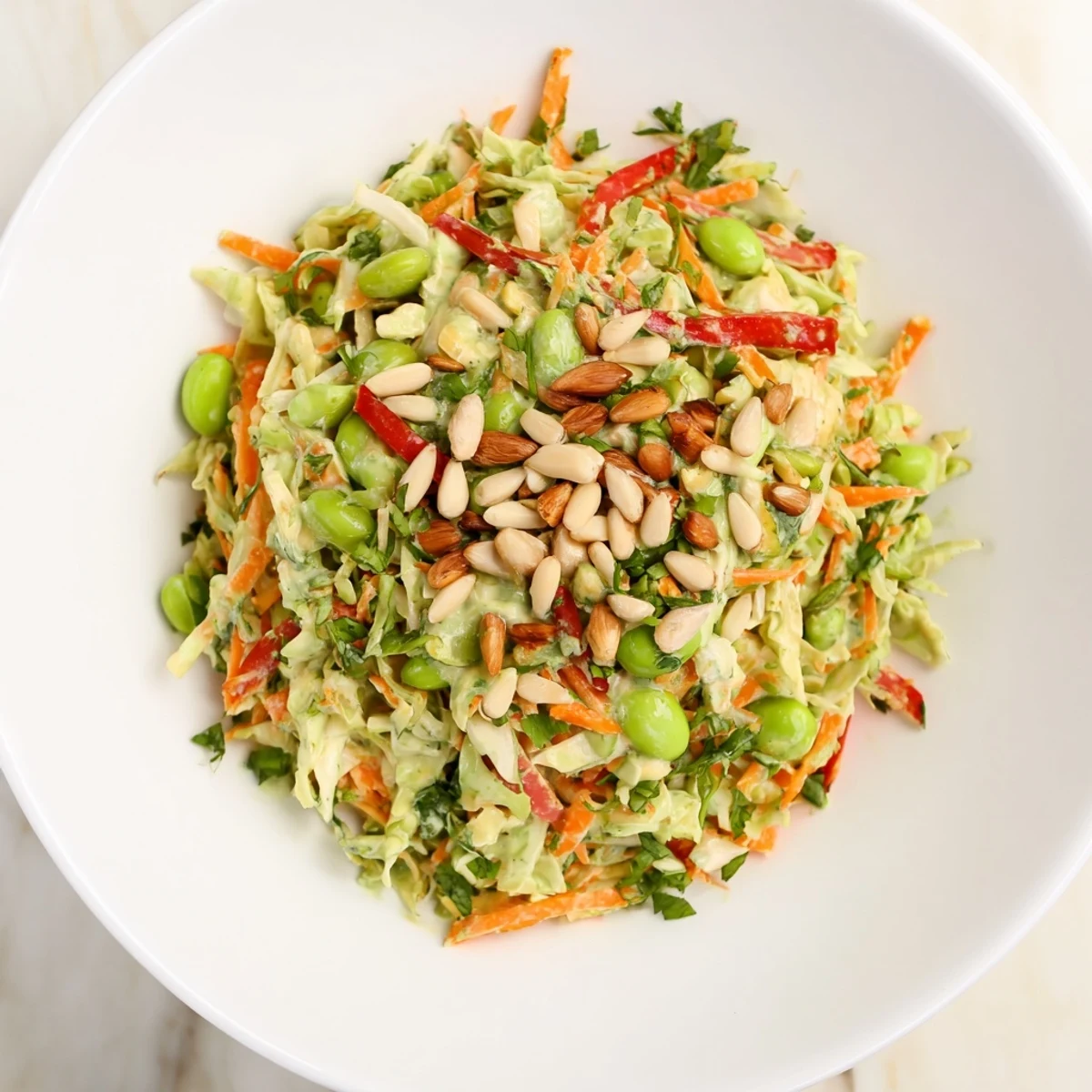Crisp, colorful Crunchy Cabbage and Edamame Salad topped with toasted almonds and sunflower seeds.