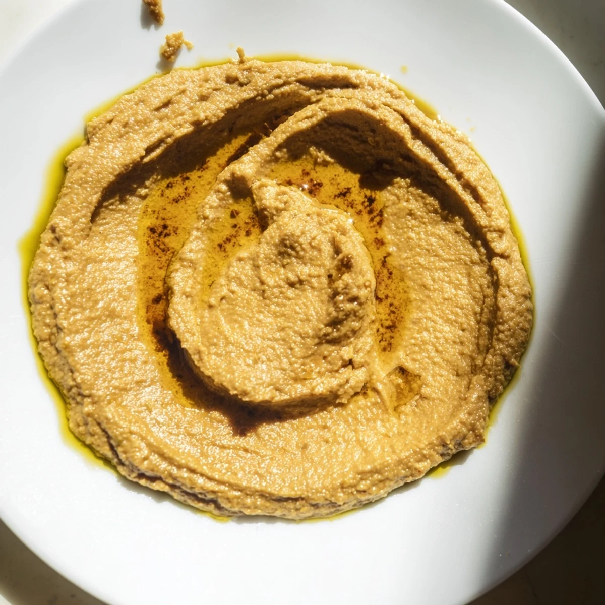 Homemade Chickpea Curry Paste in a rustic bowl, garnished with a fresh herb sprig, offering a rich, vegan dip for any gathering.