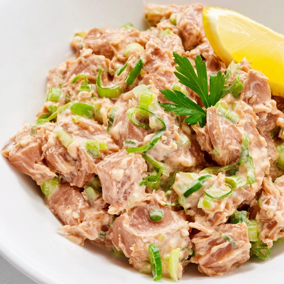 Spicy Zesty Tuna Salad in a glass jar, layered with vibrant greens and lemon slices for a packed lunch.