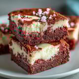 Decadent Red Velvet Cheesecake Brownies served warm with a glass of cold milk.
