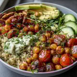 Vibrant lemon vinaigrette grain bowls with roasted chickpeas, fresh vegetables, and creamy avocado slices.  