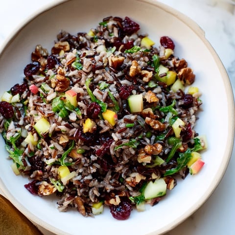 Light Forest-Inspired Wild Rice and Cranberry Salad, a vibrant bowl of fresh greens with a sweet and savory, zesty dressing.
