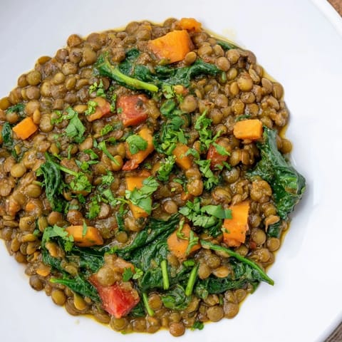 A close-up shot of rich, vibrant Lentil and Spinach Curry with visible lentils and glistening spices.