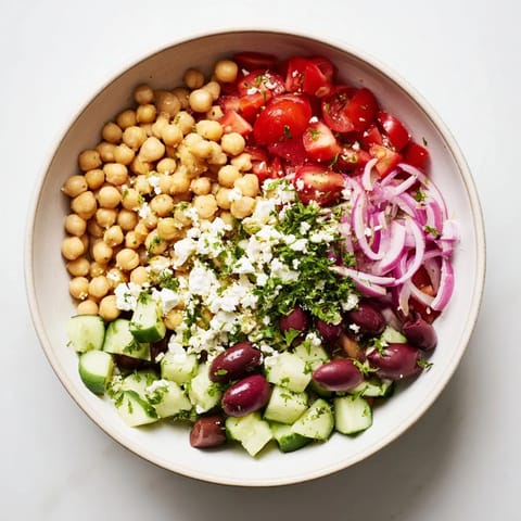Freshly assembled Mediterranean Chickpea and Feta Bowl, a flavorful vegan meal with crisp veggies.