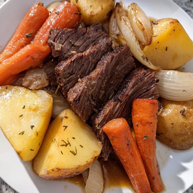 Fork-tender slices of Everyday Family Favorite Pot Roast served with carrots, potatoes, and savory juices.