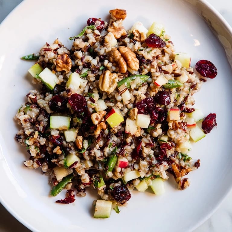 Hearty Light Forest-Inspired Wild Rice and Cranberry Salad, ready to eat, includes toasted nuts and sliced vegetables.