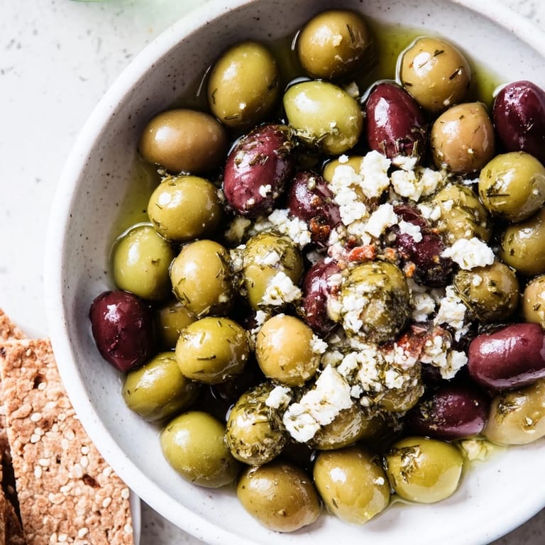 Close-up of The Cobblestone Courtyard, showcasing a platter of crackers, olives, and optional feta cheese.