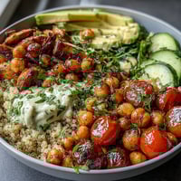 Vibrant lemon vinaigrette grain bowls with roasted chickpeas, fresh vegetables, and creamy avocado slices.  